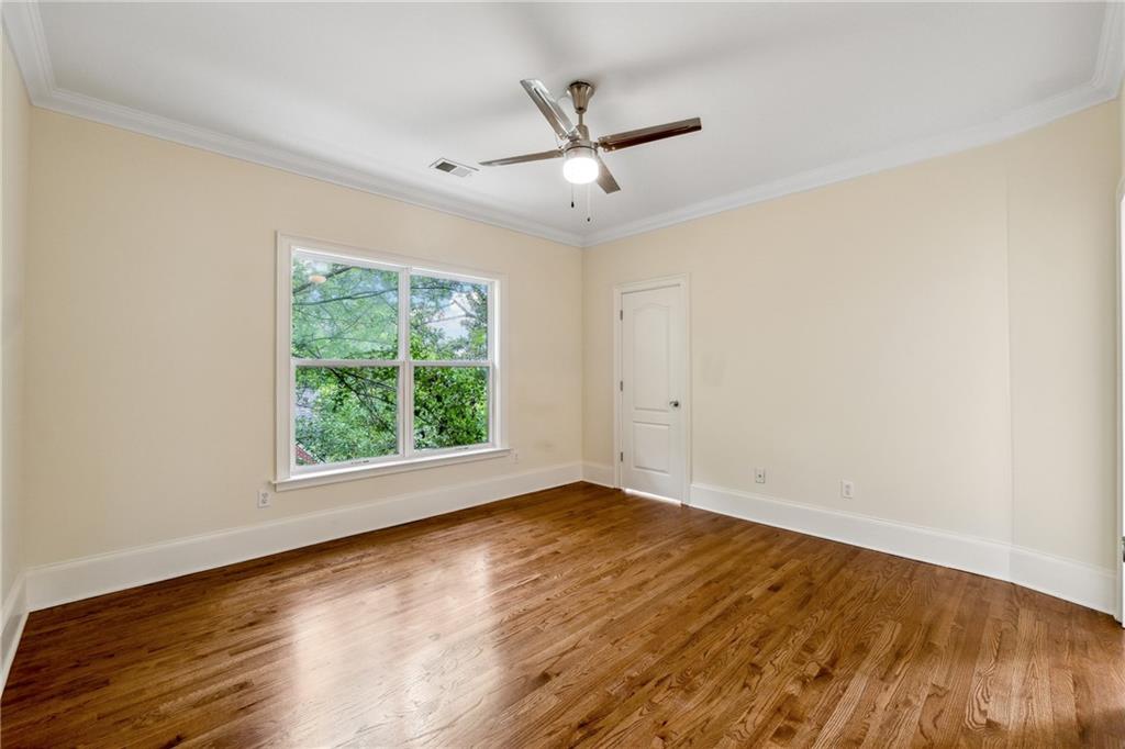 1303 North Druid Hills Road Brookhaven, GA 30319 - Photo 30 of 56 an empty room with wooden floor fan and windows