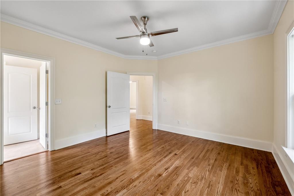 1303 North Druid Hills Road Brookhaven, GA 30319 - Photo 31 of 56 an empty room with wooden floor and ceiling fan