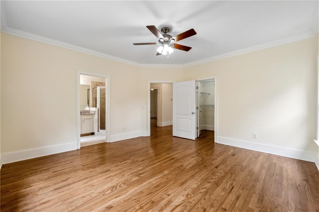 1303 North Druid Hills Road Brookhaven, GA 30319 - Photo 41 of 56 a view of an empty room with wooden floor and a ceiling fan
