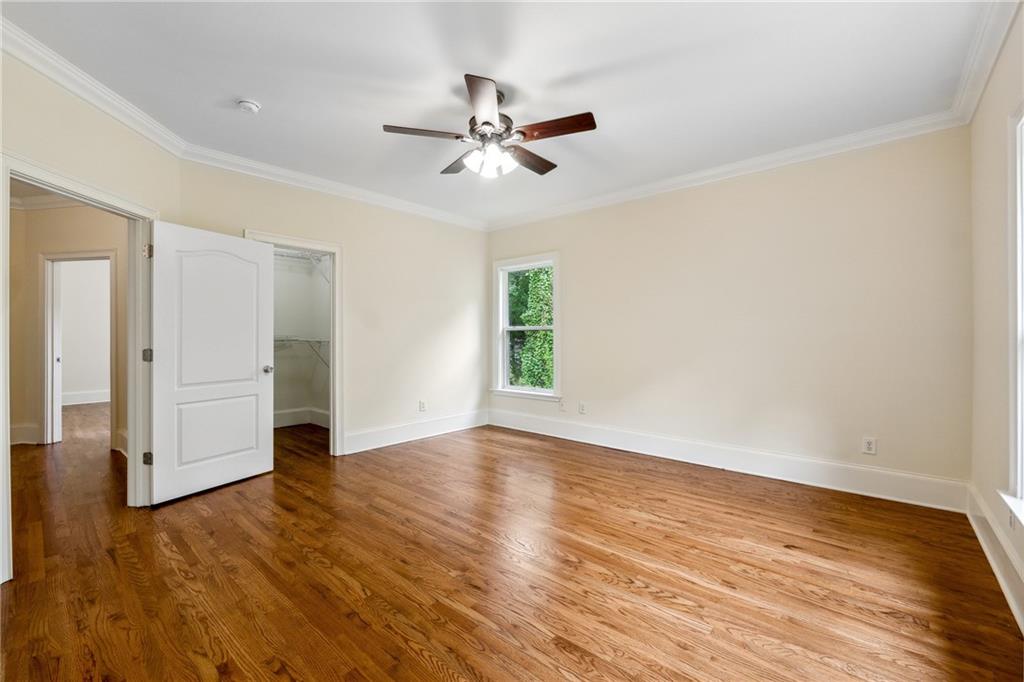 1303 North Druid Hills Road Brookhaven, GA 30319 - Photo 43 of 56 an empty room with wooden floor a ceiling fan and windows