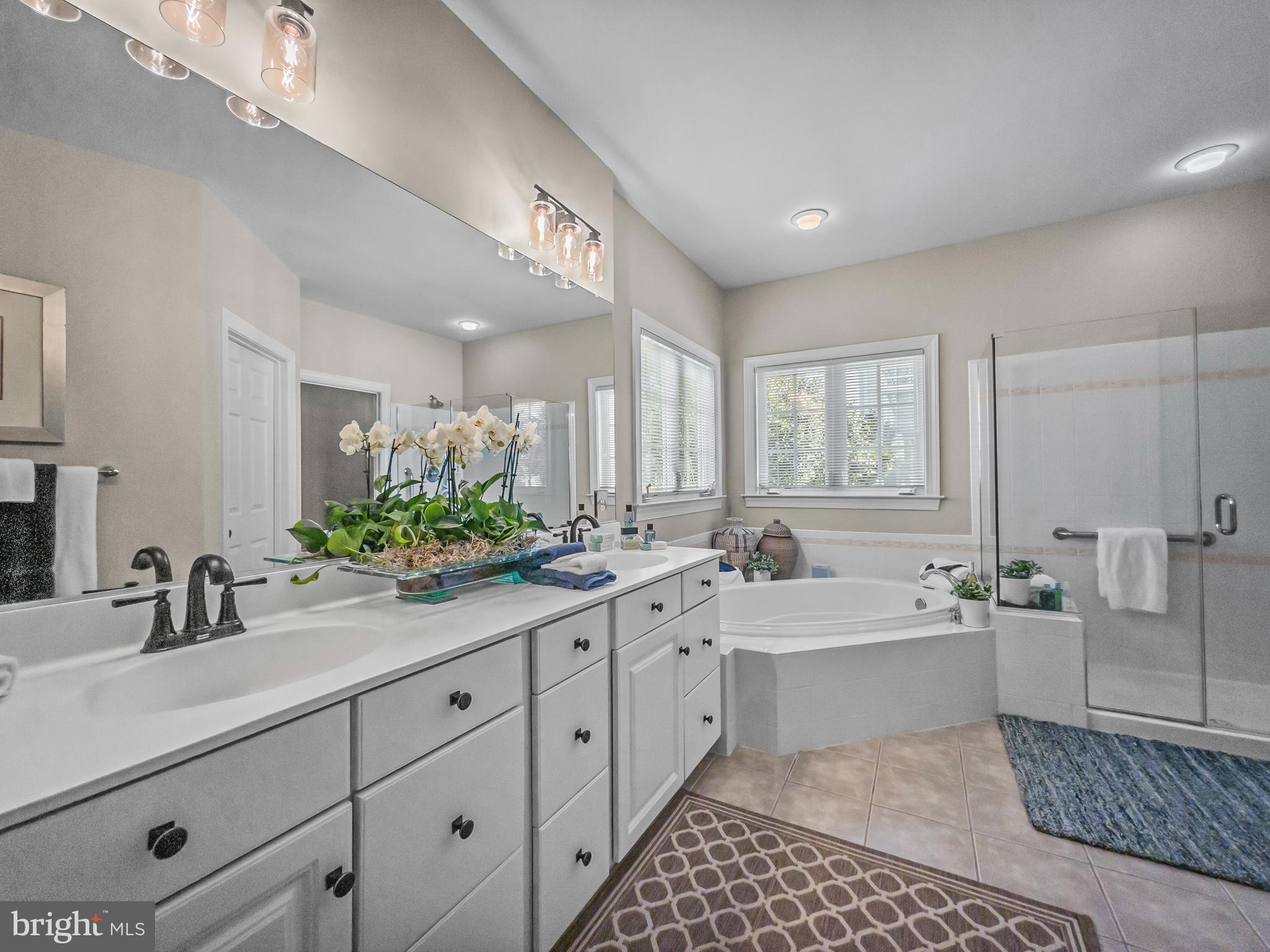 3738 Gleneagles Drive Silver Spring, MD 20906 - Photo 29 of 71 a large bathroom with a double vanity sink a large mirror a bathtub and next to a window