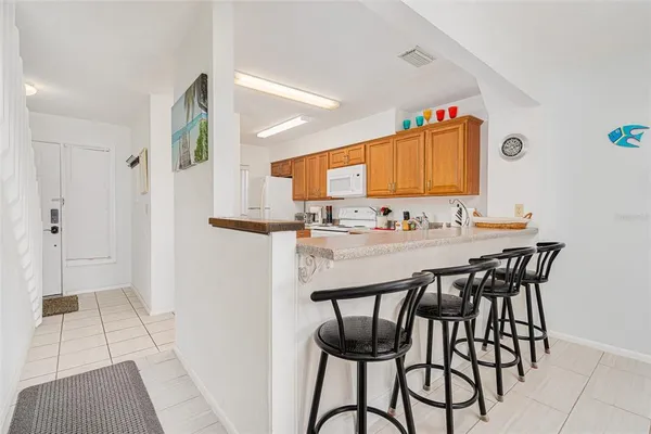 a kitchen with stainless steel appliances kitchen island granite countertop a table and chairs in it