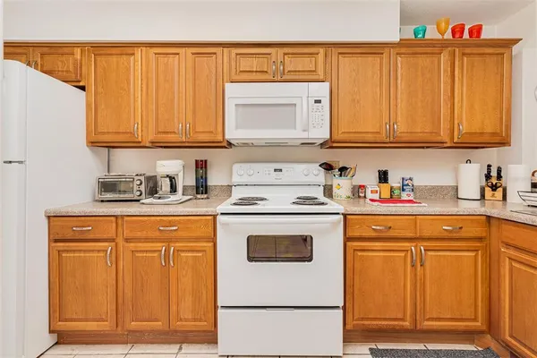 a kitchen with granite countertop cabinets and white appliances