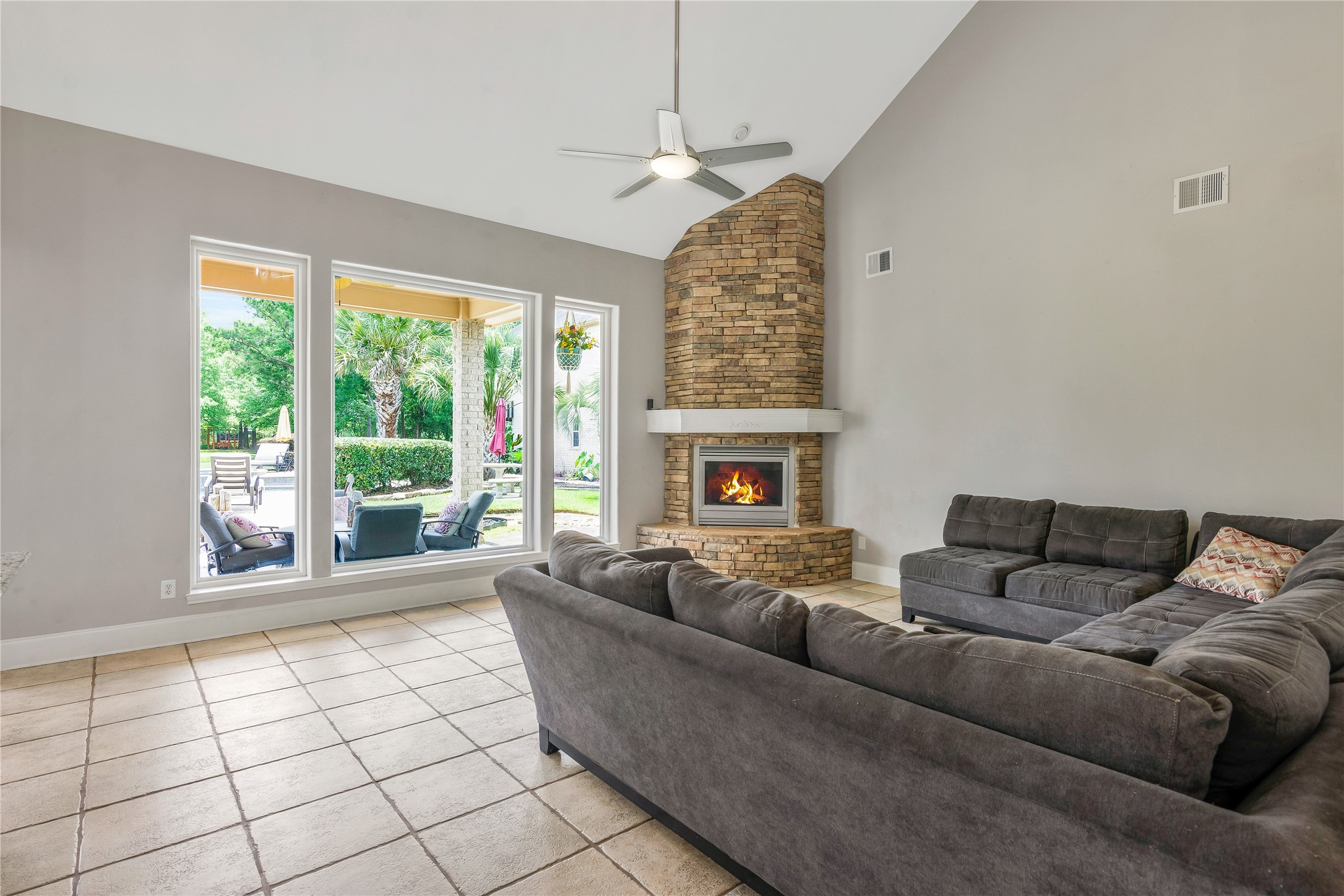 13914 Skinner Road Cypress, TX 77429 - Photo 10 of 50 Spacious living room with a stone fireplace, high ceilings, and large windows overlooking the backyard.