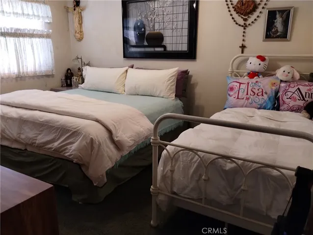 a bedroom with a bed and painting on the wall