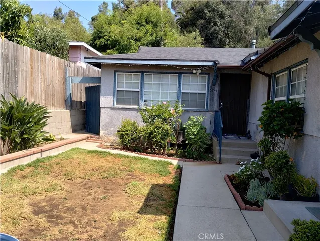 a view of a house with potted plants and a pathway
