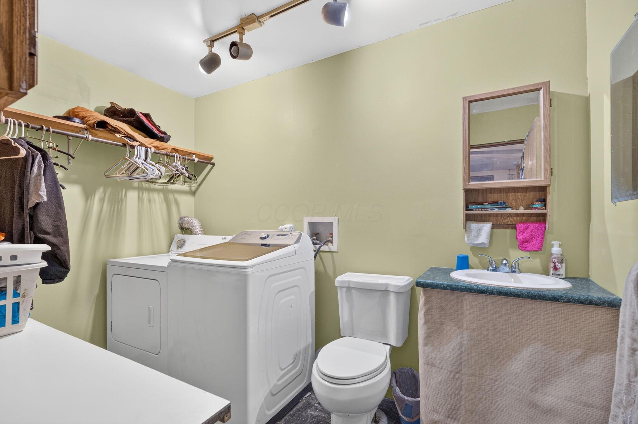 4780 North Section Line Road Radnor, OH 43066 - Photo 20 of 79 Track lighting, wall-mounted shelving with hanging rod, built-in vanity with countertop and sink, and wall-mounted medicine cabinet