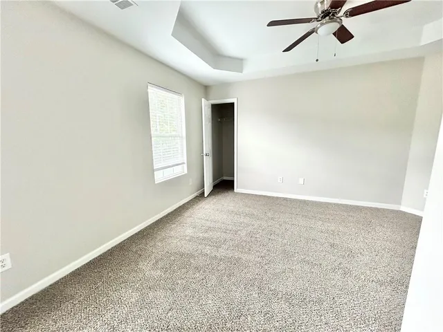 an empty room with a ceiling fan and window