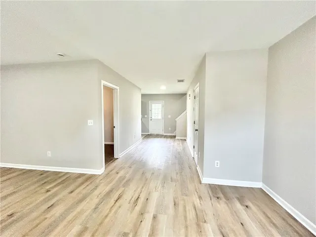 a view of a room with wooden floor and a bathroom