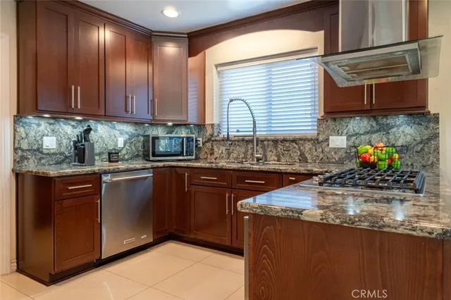 a kitchen with stainless steel appliances granite countertop wooden cabinets a sink and dishwasher