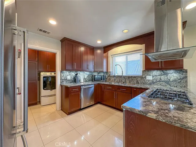 a kitchen with stainless steel appliances granite countertop a stove a sink and a refrigerator