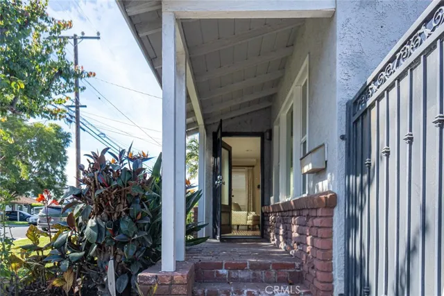 a view of a house with a potted plant and floor to ceiling window