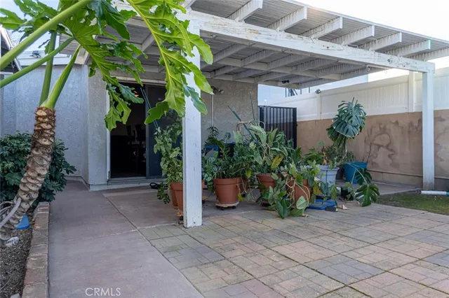 a view of a house with plants and a bench