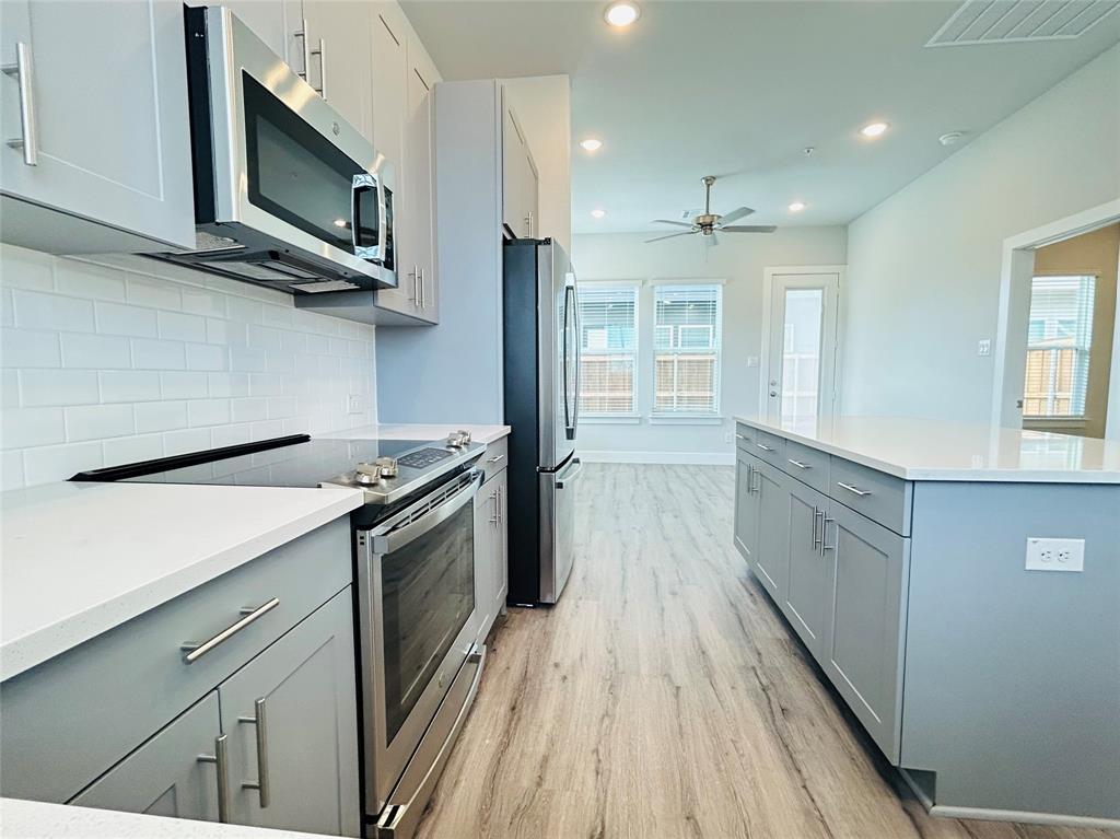 760 West Bedford Euless Road, Unit 200 Hurst, TX 76053 - Photo 22 of 39 a kitchen with stainless steel appliances hardwood floor sink stove and microwave