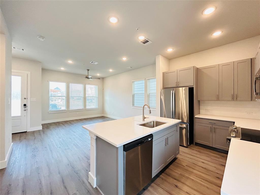760 West Bedford Euless Road, Unit 200 Hurst, TX 76053 - Photo 30 of 39 a large kitchen with kitchen island a sink dishwasher a refrigerator and wooden floor