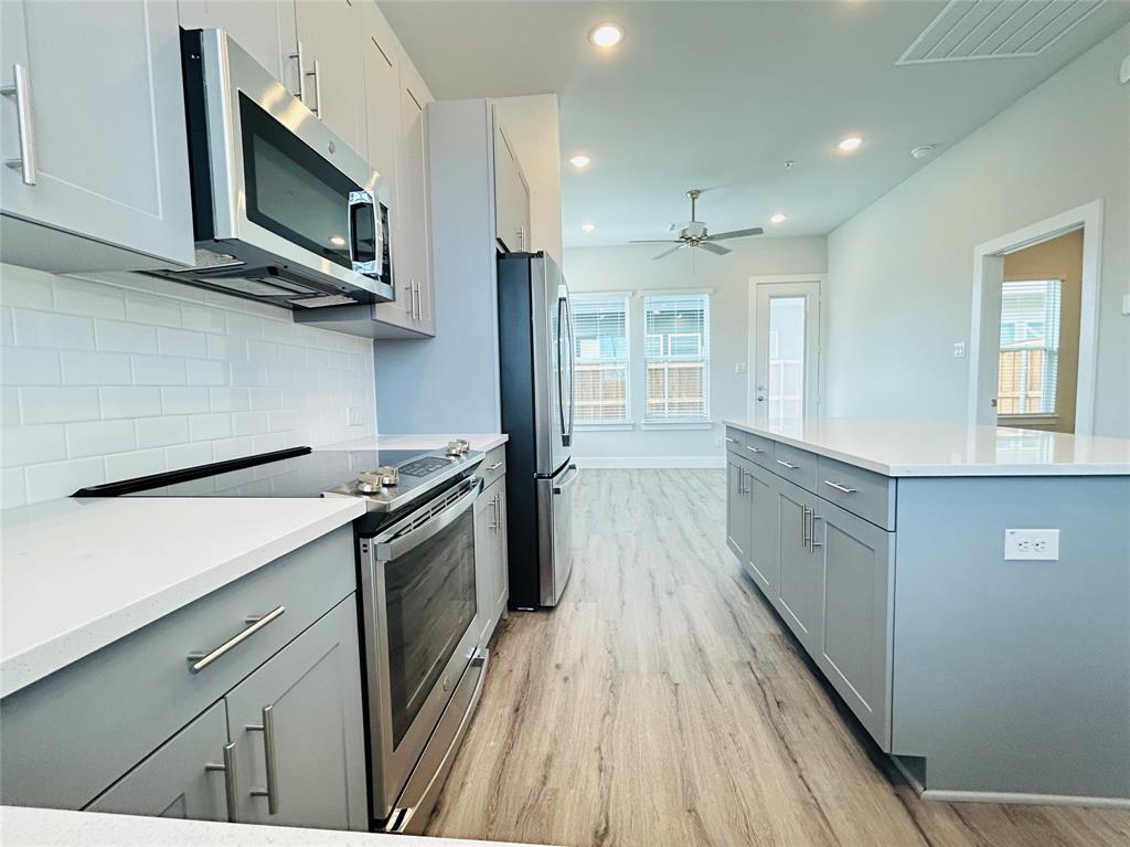 760 West Bedford Euless Road, Unit 200 Hurst, TX 76053 - Photo 8 of 39 a kitchen with stainless steel appliances a stove microwave and sink