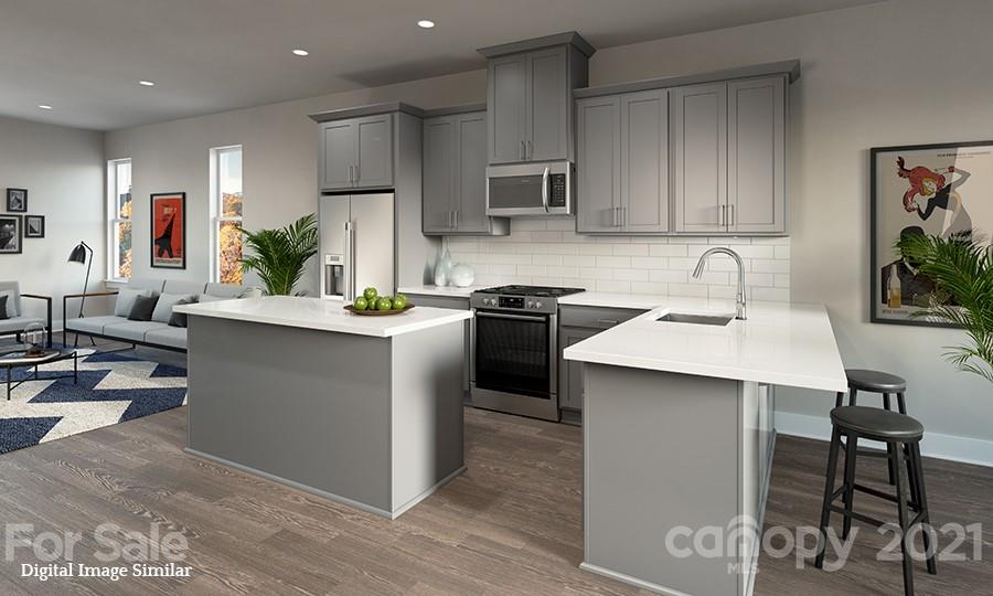 a kitchen with kitchen island stainless steel appliances a sink a stove a refrigerator cabinets and living room view