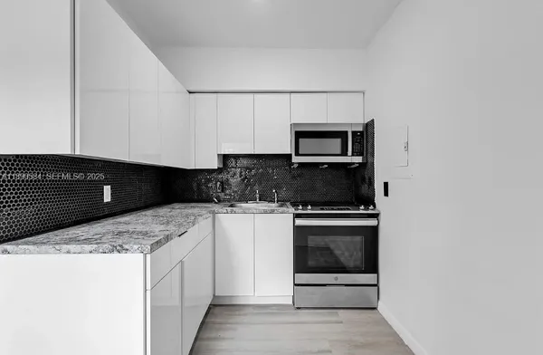 a kitchen with stainless steel appliances granite countertop a stove and a microwave