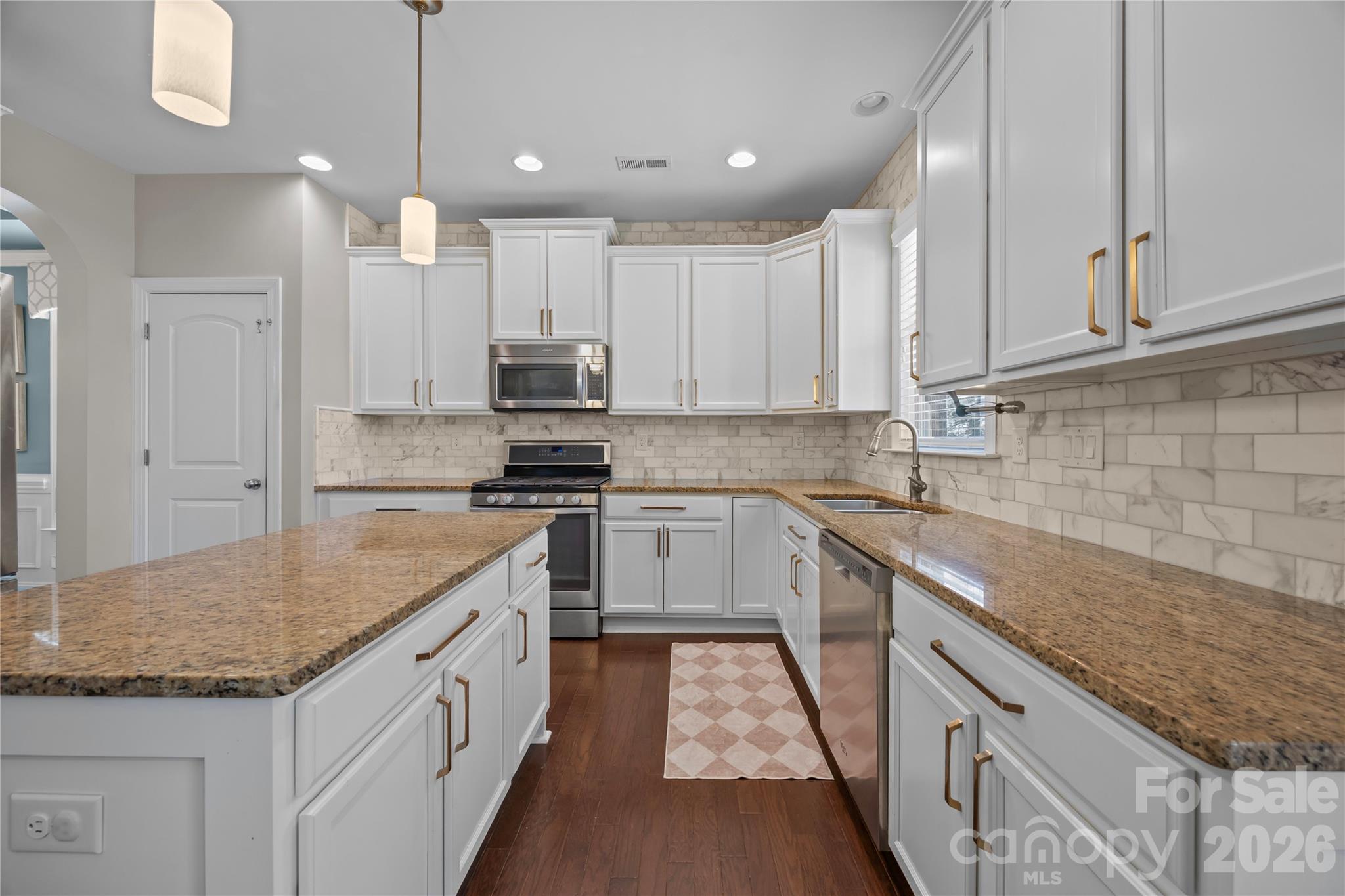 921 Rock Forest Way Fort Mill, SC 29707 - Photo 13 of 40 a kitchen with kitchen island granite countertop a sink a counter space appliances and cabinets