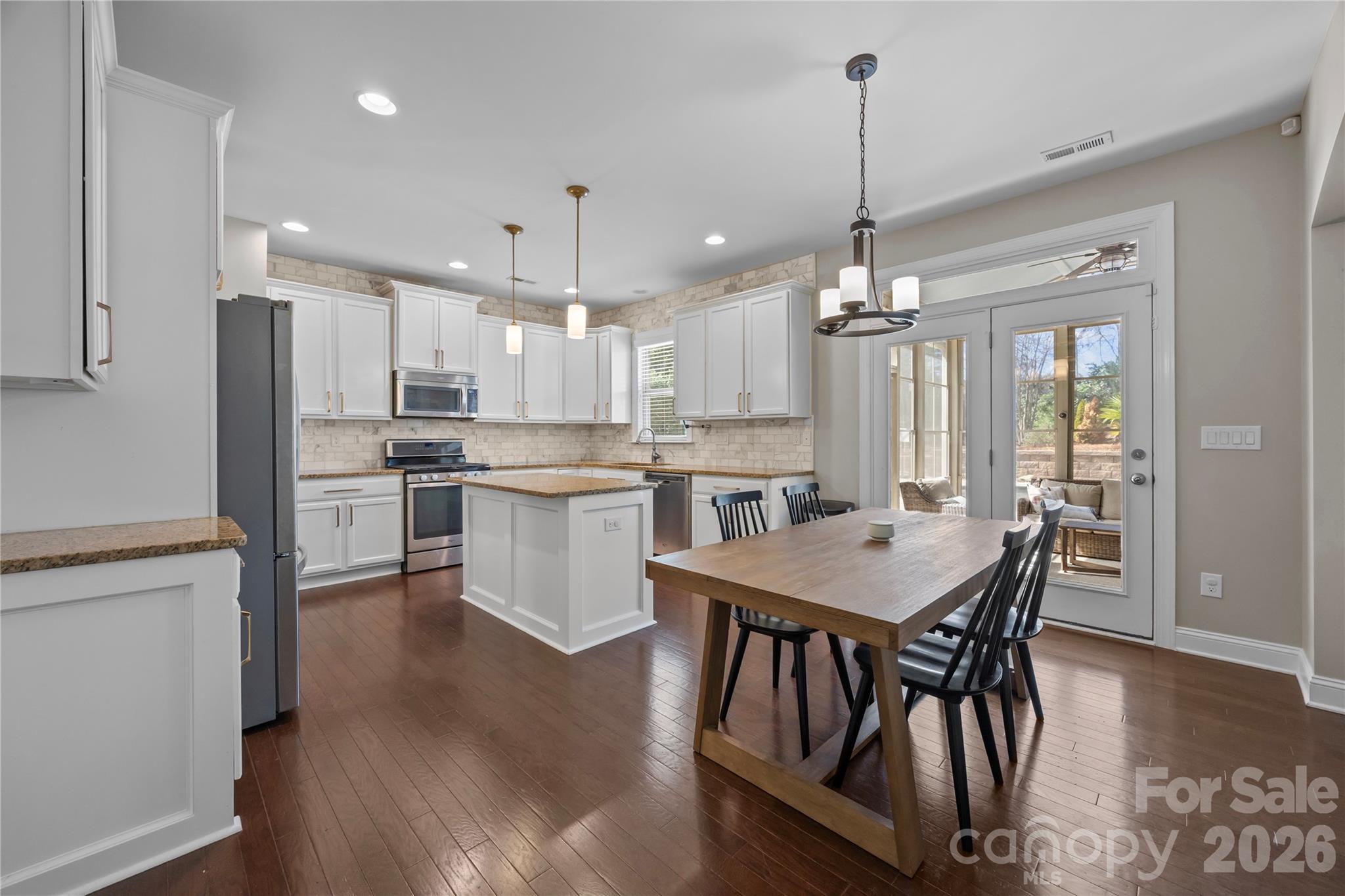 921 Rock Forest Way Fort Mill, SC 29707 - Photo 14 of 40 a kitchen with stainless steel appliances granite countertop a kitchen island a stove a table and chairs in it