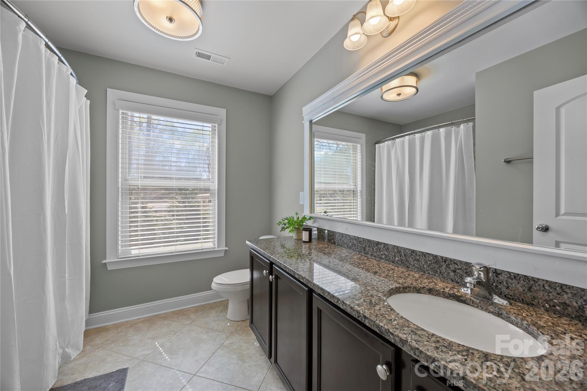 921 Rock Forest Way Fort Mill, SC 29707 - Photo 30 of 40 a bath room with a granite countertop sink and a mirror