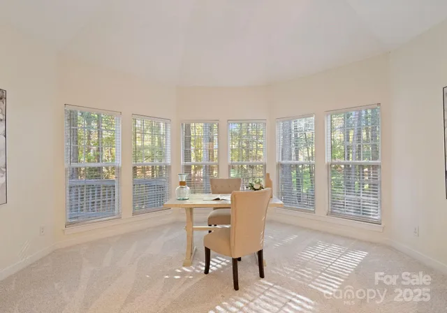 a kitchen with stainless steel appliances granite countertop a refrigerator a sink dishwasher a stove top oven a kitchen island and chairs with wooden floor