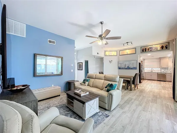 a kitchen with stainless steel appliances granite countertop a refrigerator a stove a sink and white cabinets