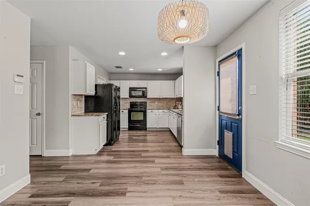 a kitchen with stainless steel appliances granite countertop a refrigerator oven stove a sink dishwasher and a refrigerator with wooden floor