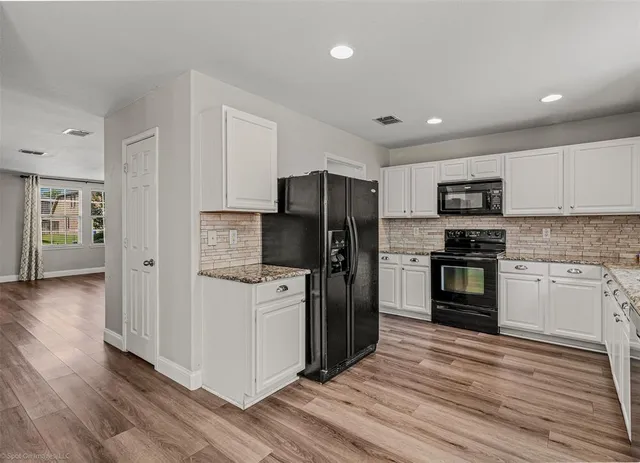a kitchen with a refrigerator and a stove top oven