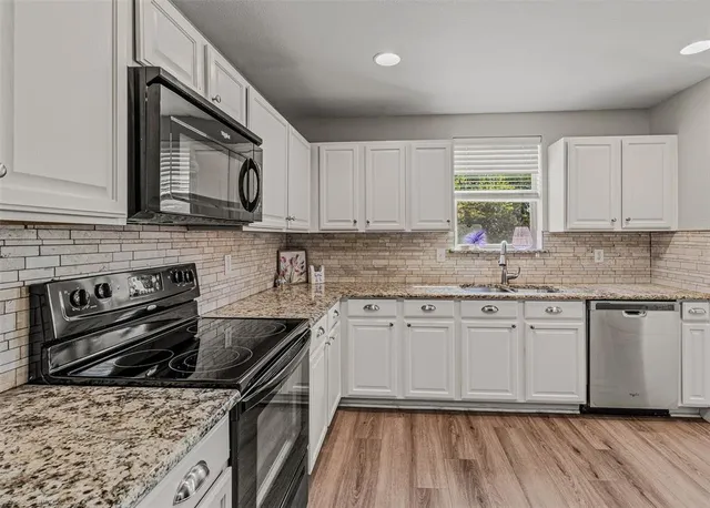 a kitchen with stainless steel appliances a sink dishwasher stove and oven