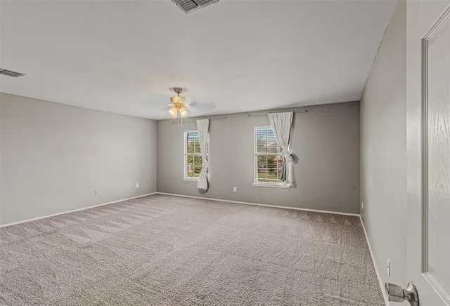 an empty room with windows and cabinet