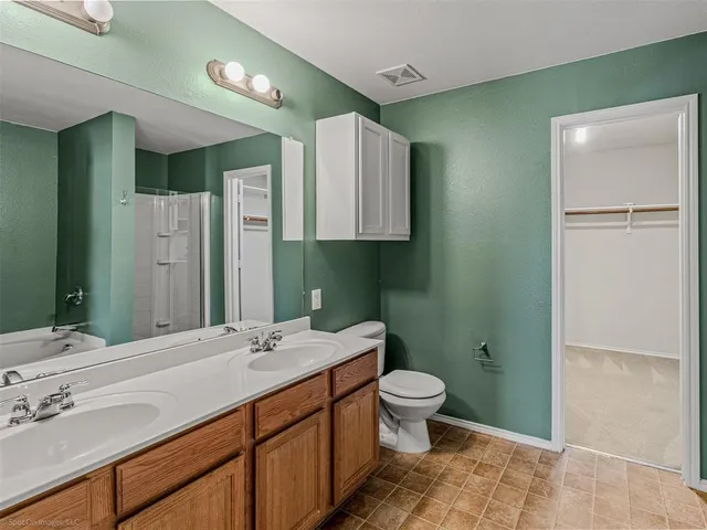 a bathroom with a double vanity sink toilet and shower