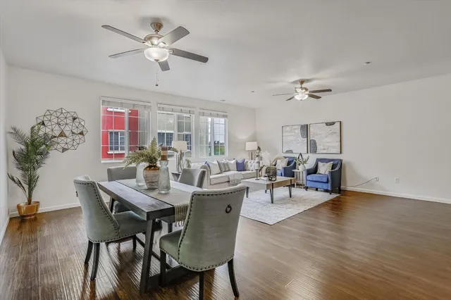 a view of a dining room with furniture a rug and wooden floor