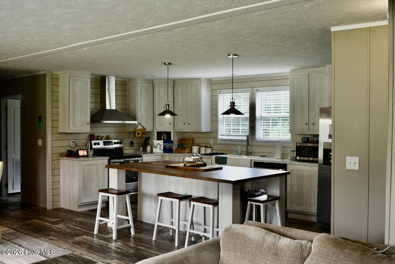1430 Nixonton Road Elizabeth City, NC 27909 - Photo 10 of 30 The key focal point to open concept is the kitchen area with has a large island, electric stove, kitchen hood, dishwasher, refrigerator and a pantry and dry bar with barn doors. There is also plenty of cabinet space for all your storage needs.