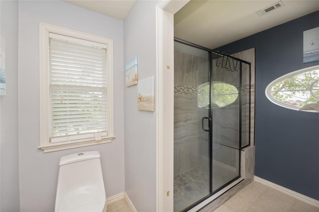 135 Kirkpatrick Road Ennis, TX 75119 - Photo 33 of 40 a bathroom with a glass shower door and a mirror