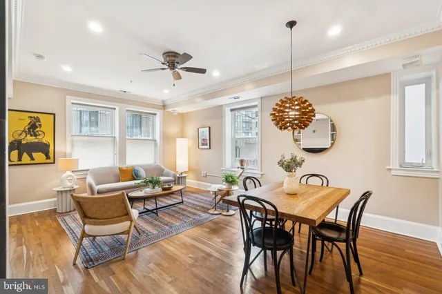 a dining room with furniture a chandelier and wooden floor