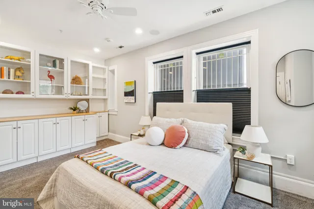 a bedroom with a bed a chandelier and mirror