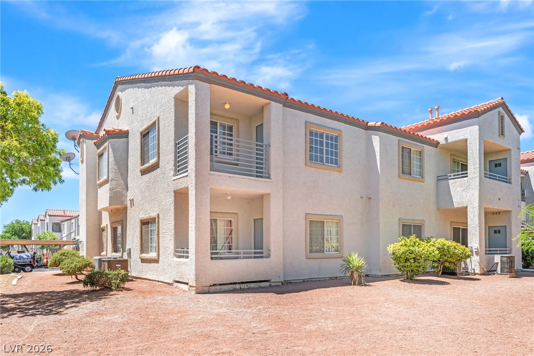 3318 North Decatur Boulevard, Unit 2152 Las Vegas, NV 89130 - Photo 31 of 58 A cream-colored multi-story building features a Mediterranean-inspired tile roof and multiple private balconies.