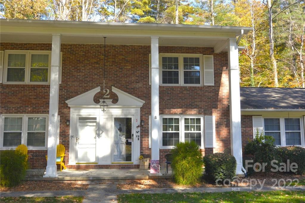 front view of a brick house with a yard