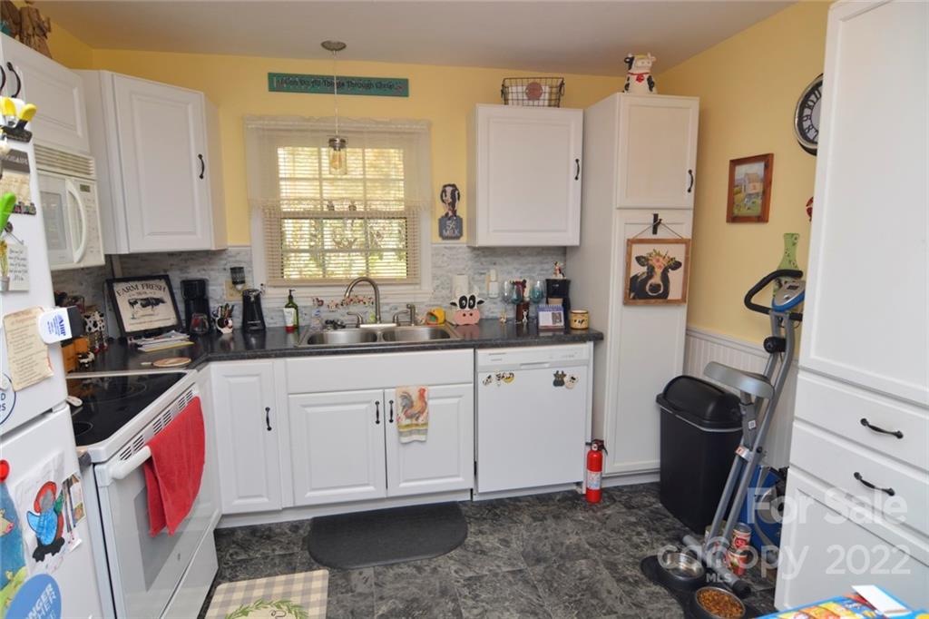 101 Boyd Drive, Unit 2B Flat Rock, NC 28731 - Photo 4 of 11 a kitchen with stainless steel appliances a stove a sink a refrigerator and cabinets