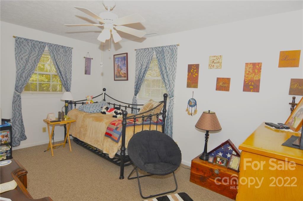 101 Boyd Drive, Unit 2B Flat Rock, NC 28731 - Photo 7 of 11 a bedroom with bed and a chandelier