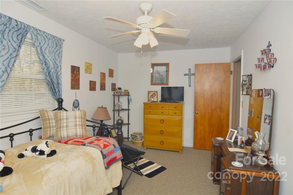 101 Boyd Drive, Unit 2B Flat Rock, NC 28731 - Photo 8 of 11 a bedroom with a bed and a chandelier