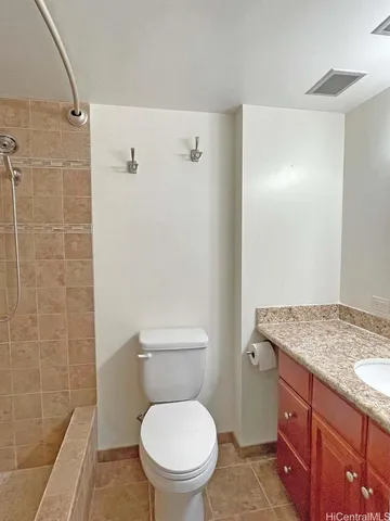 a bathroom with a granite countertop toilet a sink and a shower