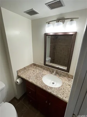 a bathroom with a granite countertop sink and a mirror