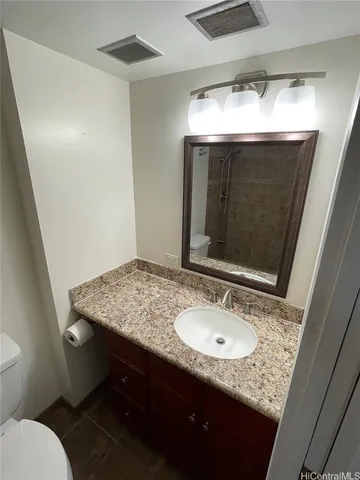 a bathroom with a granite countertop sink and a mirror