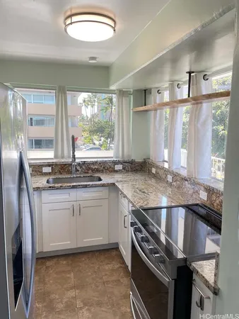 a kitchen with granite countertop a sink and a stove