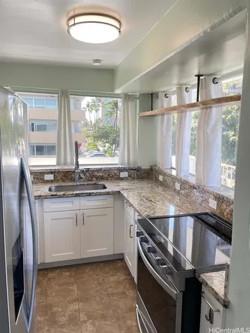 a kitchen with granite countertop a sink and a stove