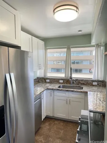 a kitchen with stainless steel appliances granite countertop a sink a stove a refrigerator and island