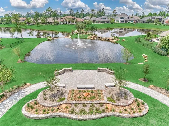 a view of a lake with a yard and large trees