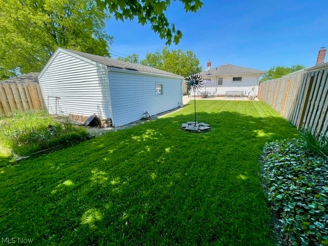 28634 Forest Road Willowick, OH 44095 - Photo 8 of 39 Expansive backyard featuring a lush lawn, white vinyl-sided detached garage, and a wooden privacy fence